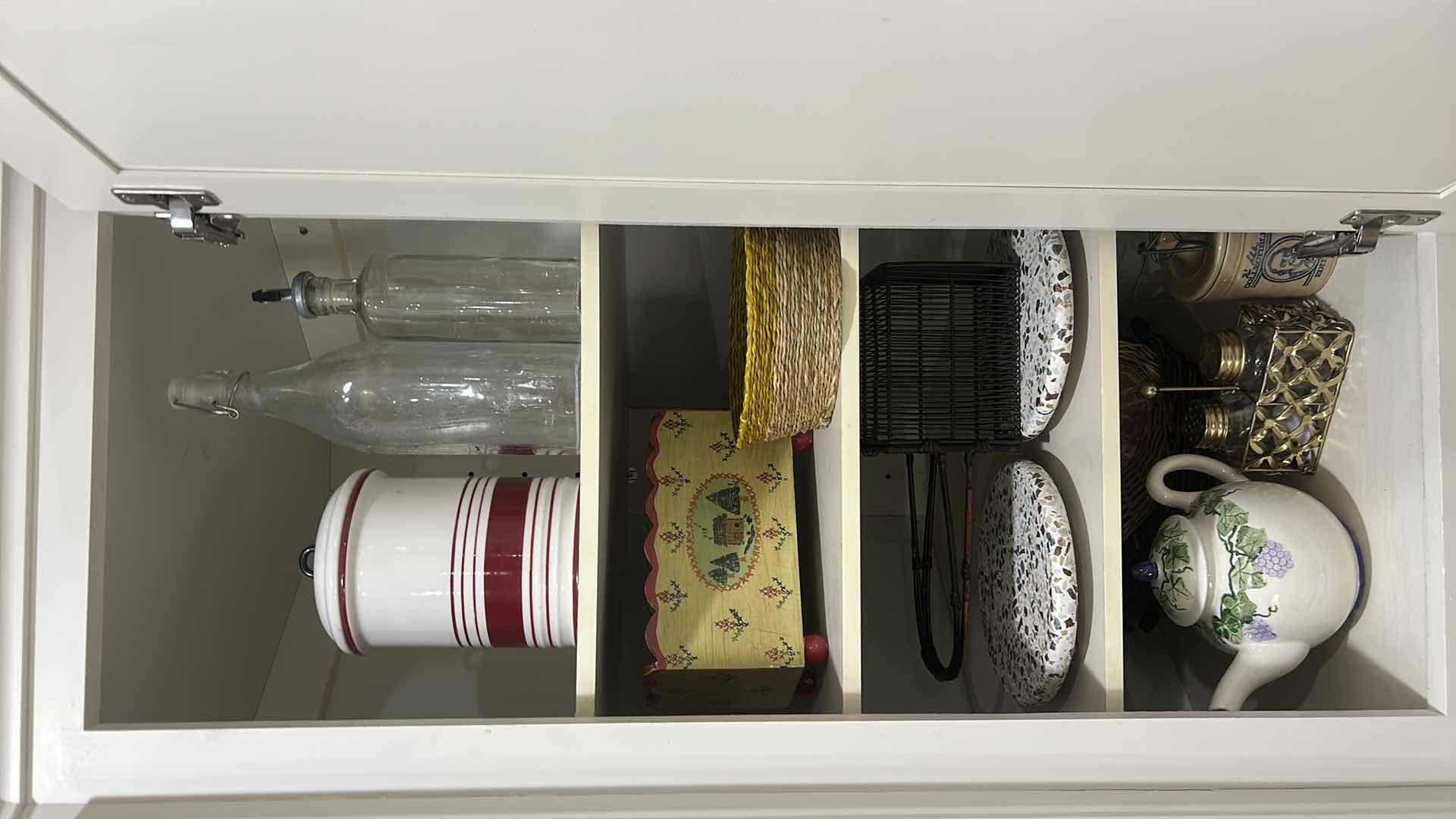Photo 1 of CONTENTS OF CABINET IN KITCHEN, CANISTER, TEA, POT, TRIVETS, AND MORE