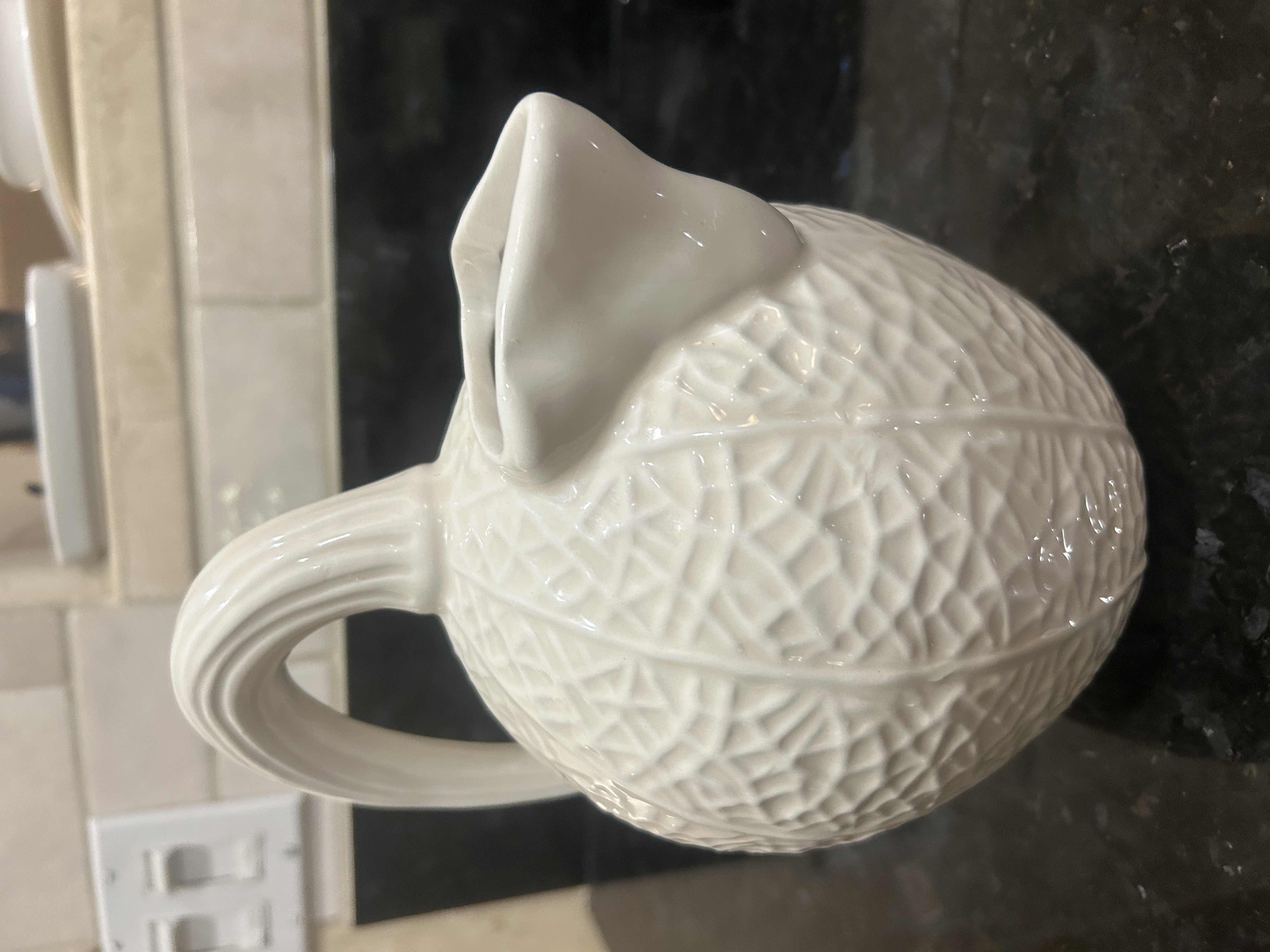 Photo 1 of BLOOMINGDALES WHITE CERAMIC PITCHER IS DESIGNED WITH A UNIQUE TEXTURED REPTILIAN PATTERN REMINISCENT OF A KAISER REPTILE PATTERN VASE.
