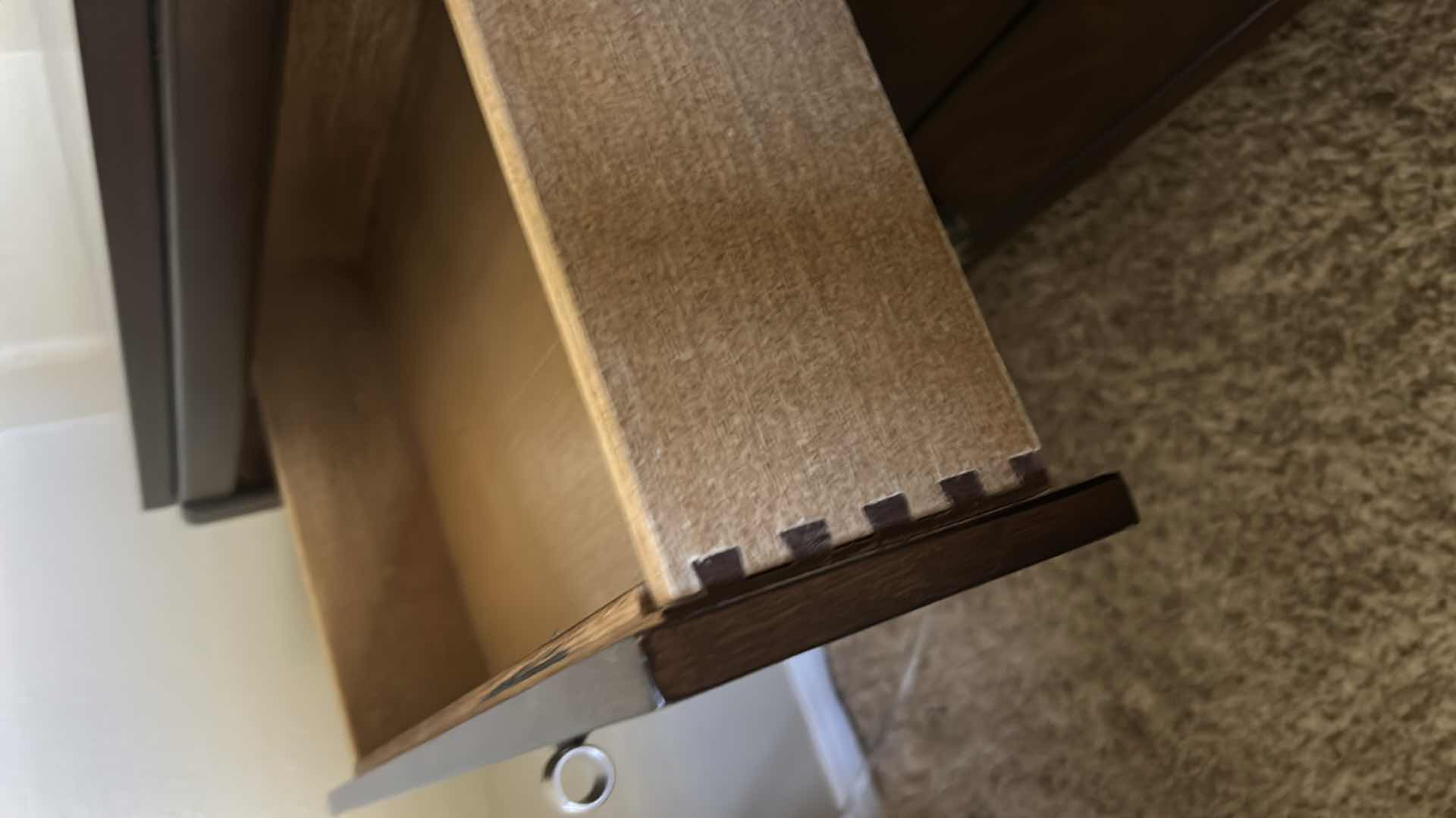 Photo 1 of DARK WOOD THREE-DRAWER NIGHTSTAND W HIGH-GLOSS FINISH BURLED WOOD VENEER DRAWER FRONTS & POLISHED METAL KNOBS.