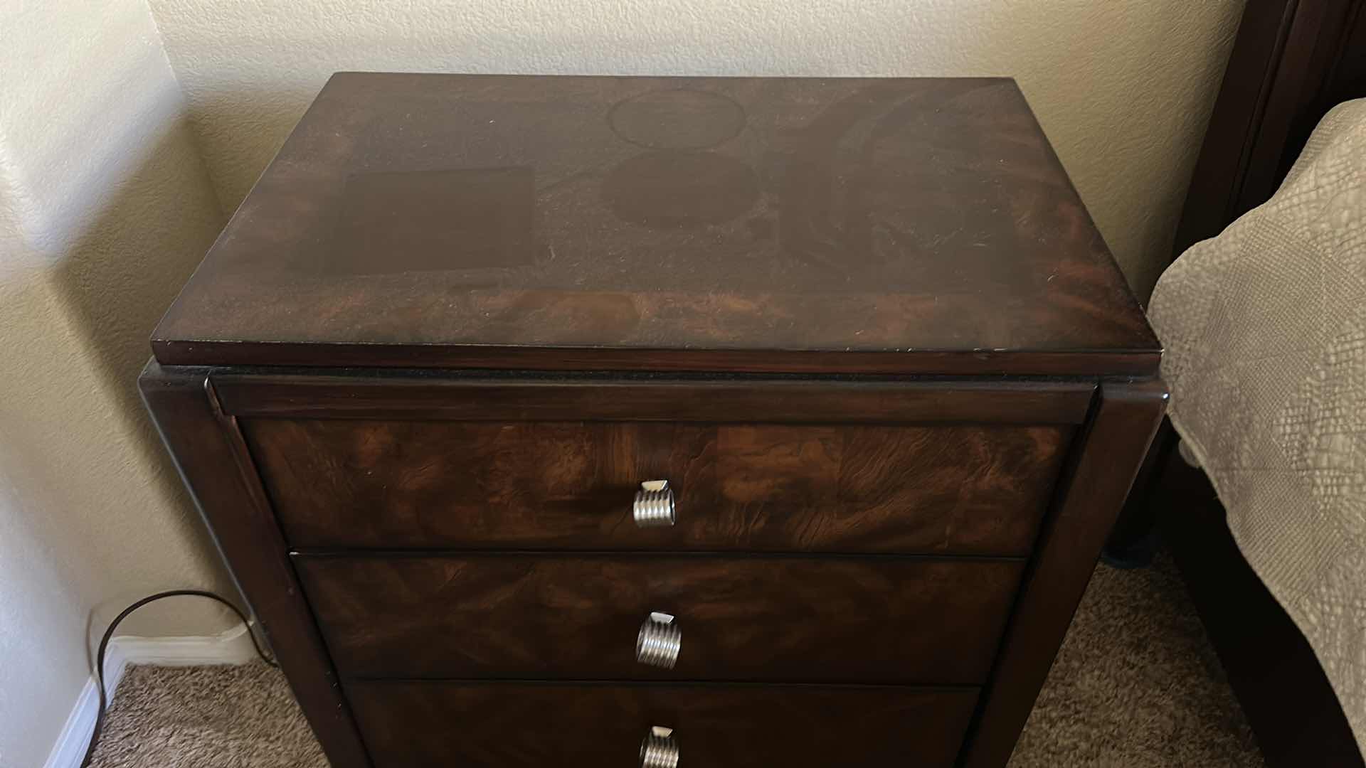 Photo 1 of DARK WOOD THREE-DRAWER NIGHTSTAND W HIGH-GLOSS FINISH BURLED WOOD VENEER DRAWER FRONTS & POLISHED METAL KNOBS.