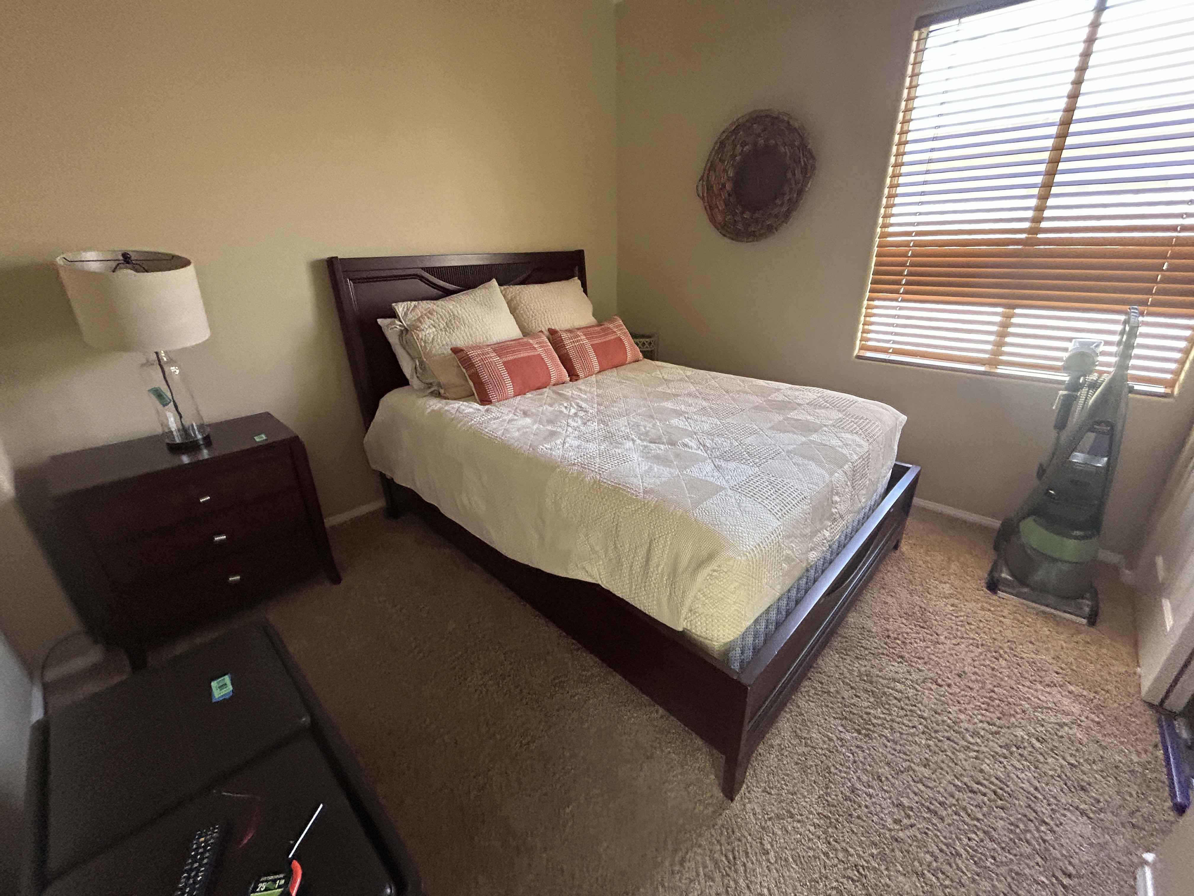 Photo 1 of DARK WOOD PLATFORM BED FEATURING A SLEIGH-STYLE HEADBOARD, MATCHING FOOTBOARD, AND NEUTRAL QUILTED BEDDING WITH ACCENT PILLOWS. INCLUDES SERTA QUEEN MATTRESS. (MATTRESS MEASURES 5 FEET X 81” INCHES HEADBOARD HEIGHT 52 1/2 INCHES)