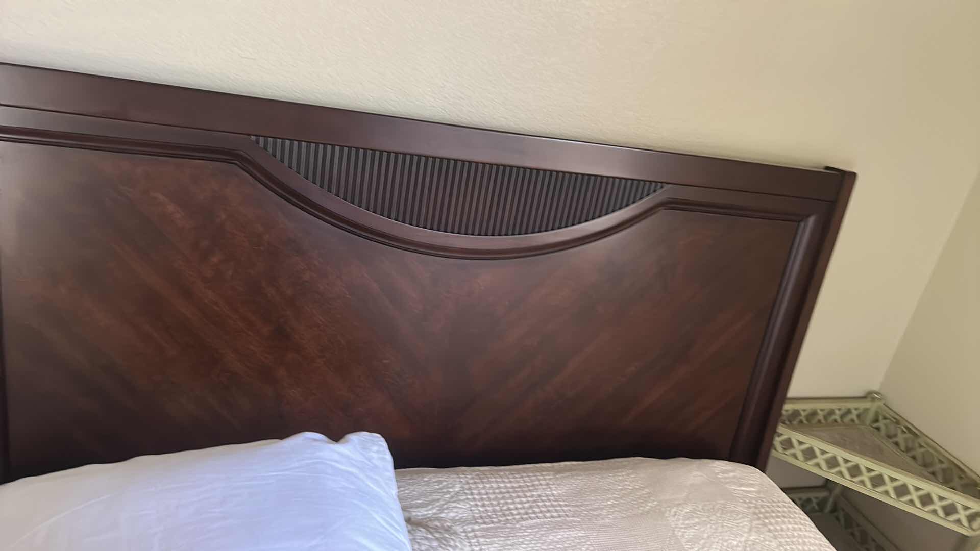 Photo 1 of DARK WOOD PLATFORM BED FEATURING A SLEIGH-STYLE HEADBOARD, MATCHING FOOTBOARD, AND NEUTRAL QUILTED BEDDING WITH ACCENT PILLOWS. INCLUDES SERTA QUEEN MATTRESS. (MATTRESS MEASURES 5 FEET X 81” INCHES HEADBOARD HEIGHT 52 1/2 INCHES)