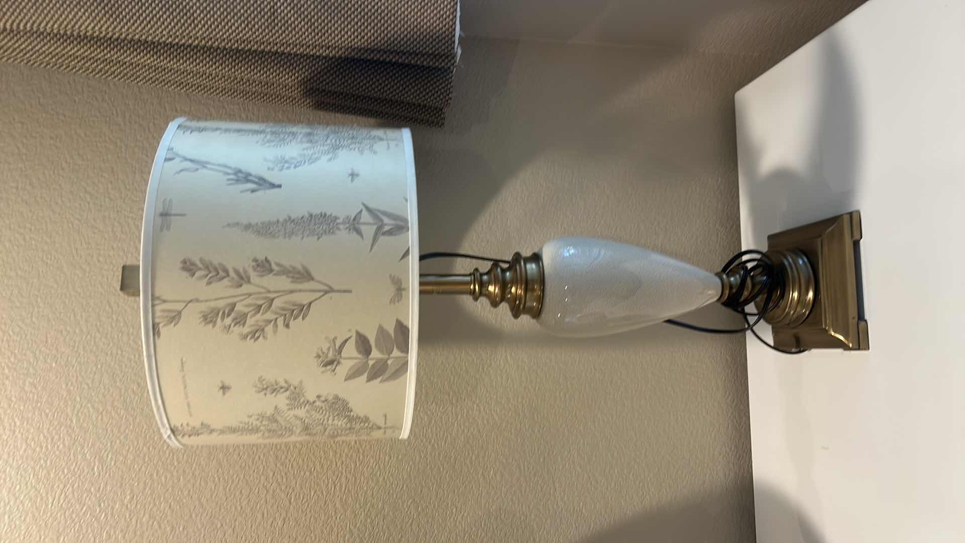 Photo 1 of TABLE LAMP FEATURES A WHITE CERAMIC VASE BODY AND A BOTANICAL PATTERNED SHADE. H34”