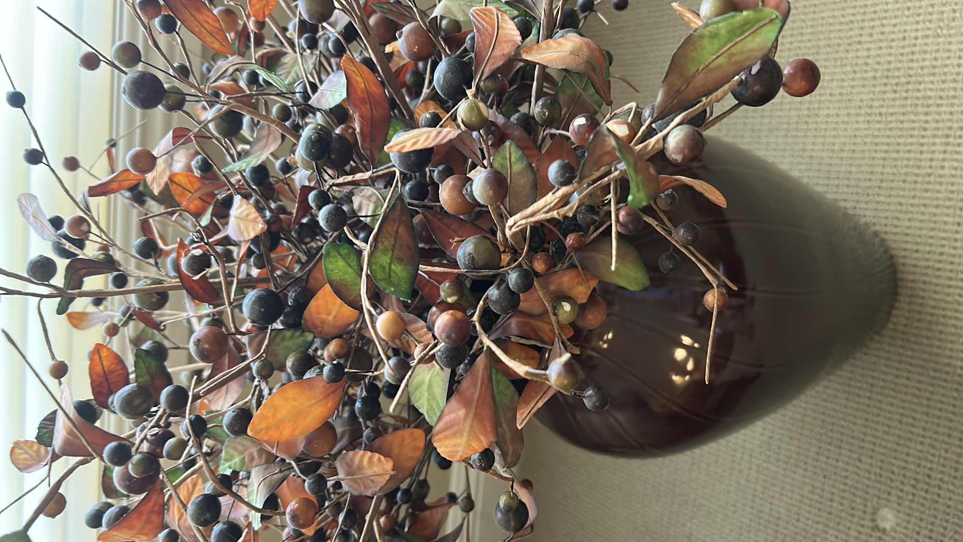 Photo 1 of FAUX BLUE BERRY STEM W ORANGE FOLIAGE IN RED CERAMIC VASE H 3