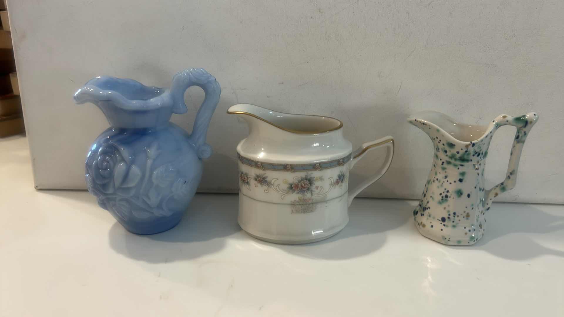 Photo 1 of BLUE SLAG GLASS ROSE PITCHER, PORCELAIN FLORAL CREAMER, & SPATTERWARE ART POTTERY PITCHER H4.5” $65
