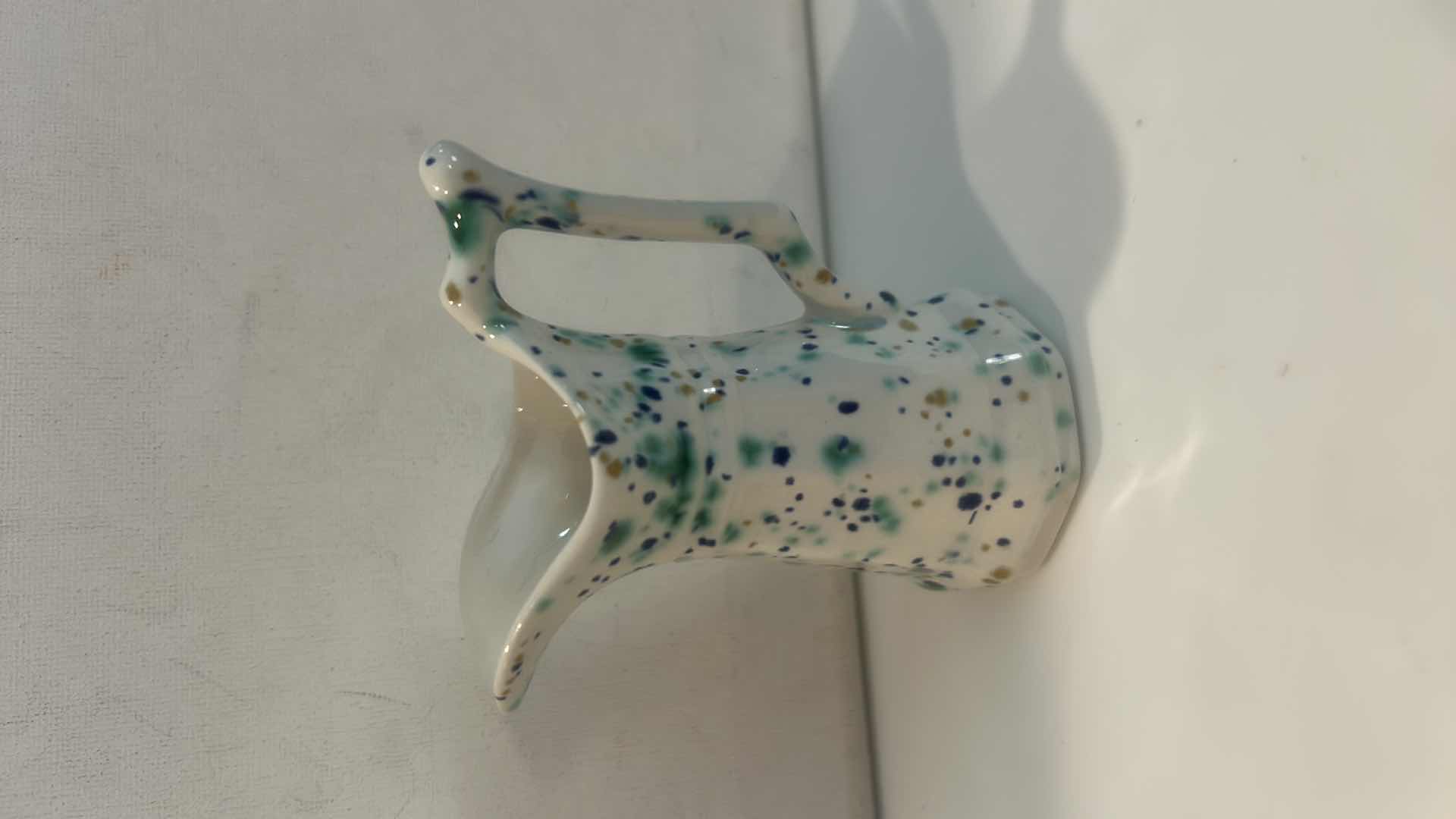 Photo 1 of BLUE SLAG GLASS ROSE PITCHER, PORCELAIN FLORAL CREAMER, & SPATTERWARE ART POTTERY PITCHER H4.5” $65