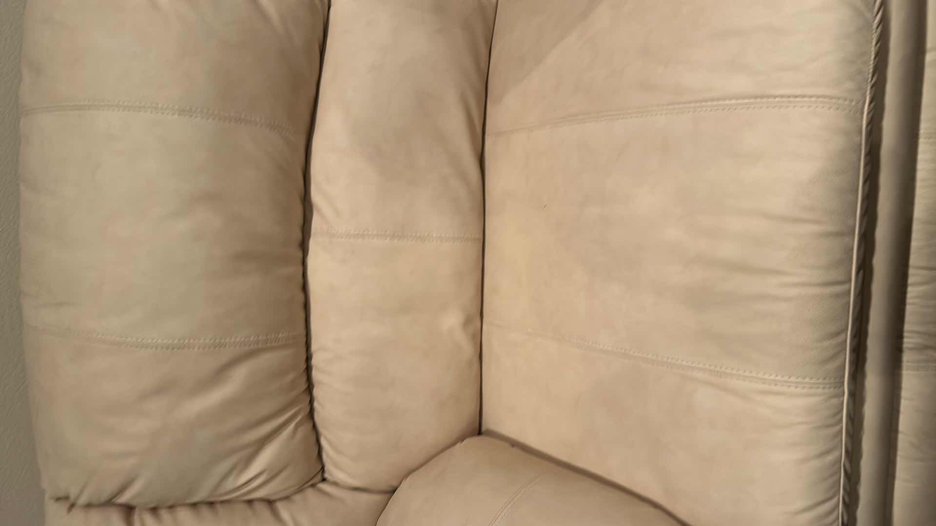 Photo 1 of OFF WHITE LEATHER RECLINING SOFA W COMFORTABLE PADDED CUSHIONS W DIAGONAL SEAM DETAIL 2 ACCENT PILLOWS